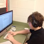 student typing on computer