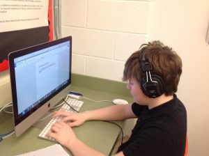 student typing on computer